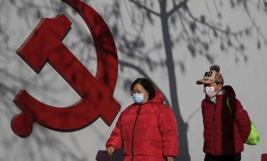 Residents wearing face masks walk by tree shadow cast on a Communist Party's logo near a residential area in Beijing, Thursday, March 2, 2023. Chinese leader Xi Jinping's agenda for the annual meeting of the ceremonial legislature: Revive the economy by encouraging consumers to spend more now that severe anti-virus controls have ended, and install a government of loyalists to intensify Communist Party control over the economy and society. (AP Photo/Andy Wong)