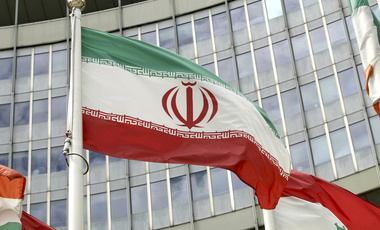The Iranian flag waves outside of the UN building that hosts the International Atomic Energy Agency