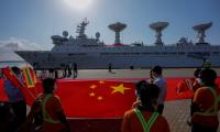 Sri Lankan port workers hold a Chinese national flag to welcome Chinese research ship